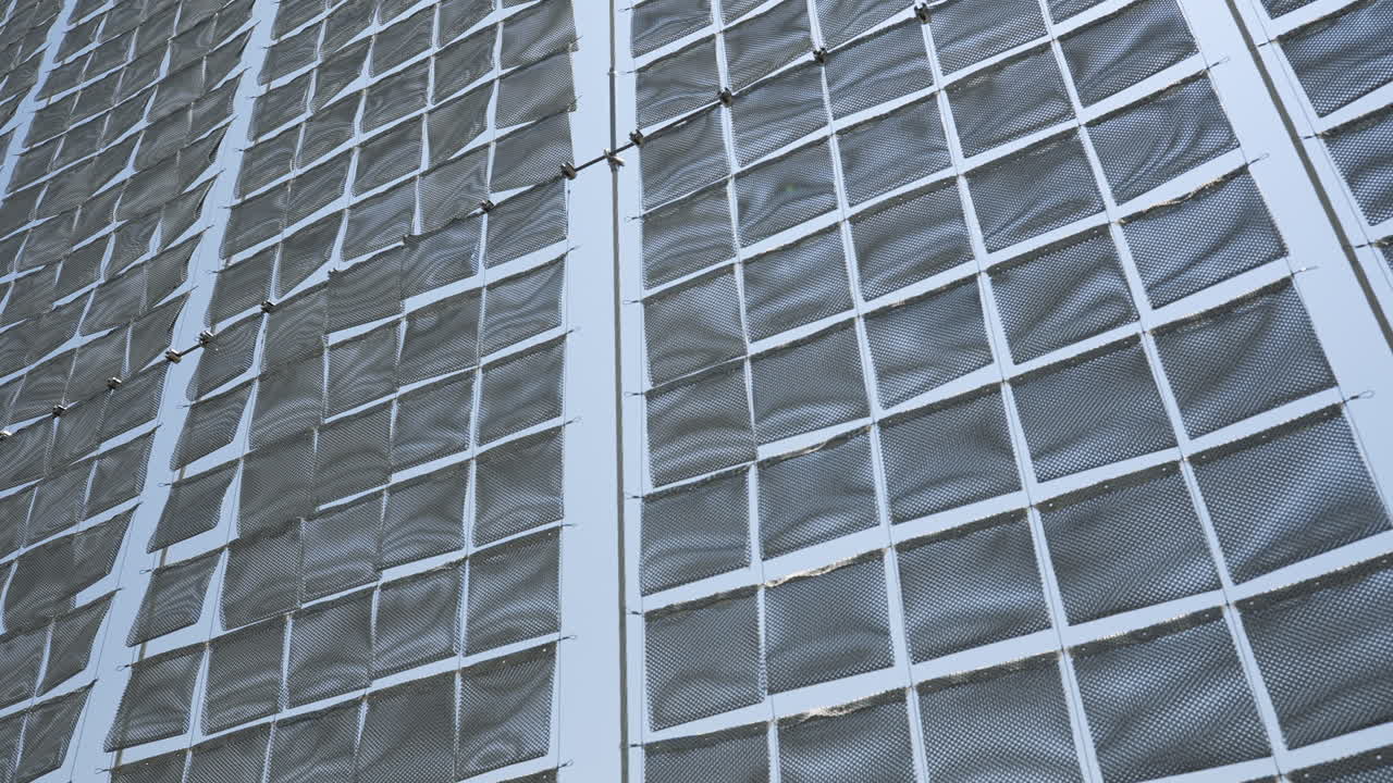 Modern art installation of silver cloth panels blowing in the wind.