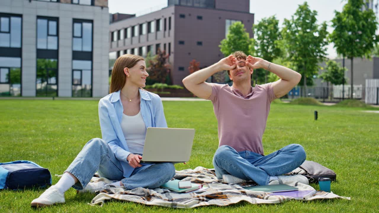 Studenci online uczą się obsługi kosiarki, siedząc pod kocem z laptopami. Dwóch zdalnych menedżerów