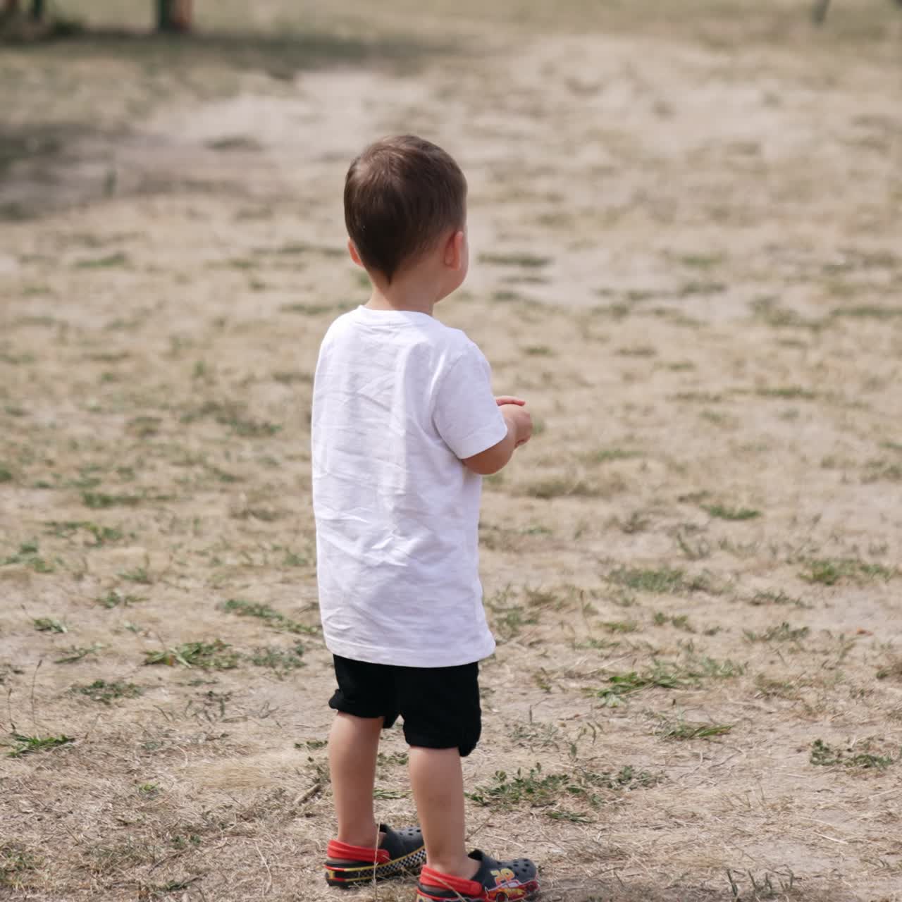 Playing outdoor in park small child. Baby boy playing in the park