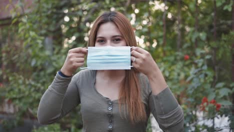 a lady putting on a face mask