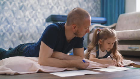 young father and daughter lie on floor