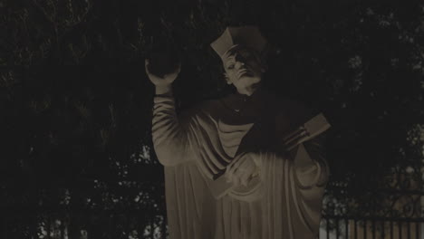 a static shot of an ancient marble statue of a person at night