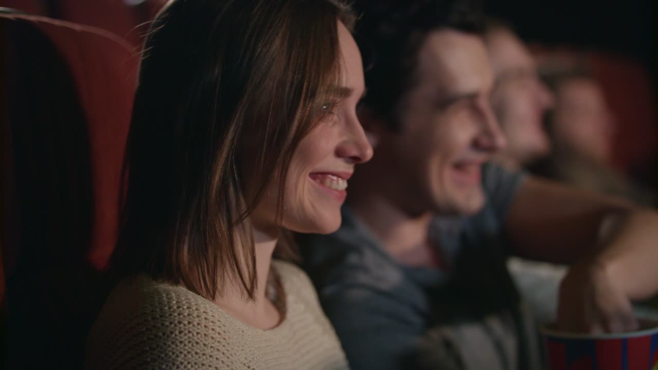 mujer sonriente viendo una película. pareja romántica viendo una película de comedia
