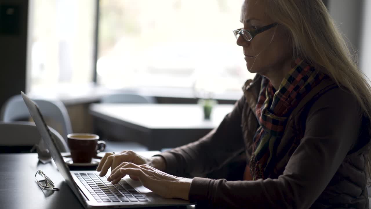 Woman working on laptop in cafe