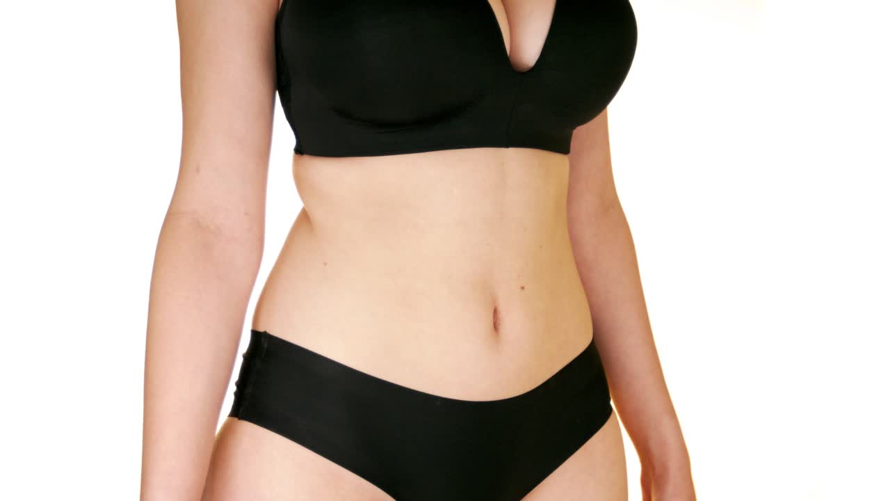 Close up on fit belly of young woman against white background