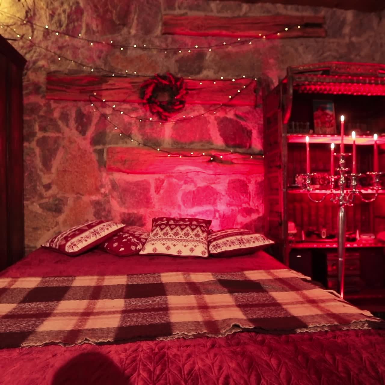 Old-fashioned style bedroom in private manor outside the city. Festively decorated cozy room in castle-like manner lit in red light