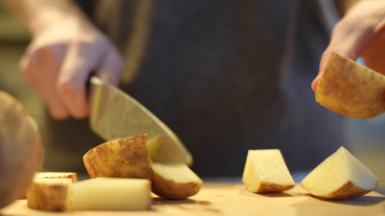 A man cutting potatoes up for dinner