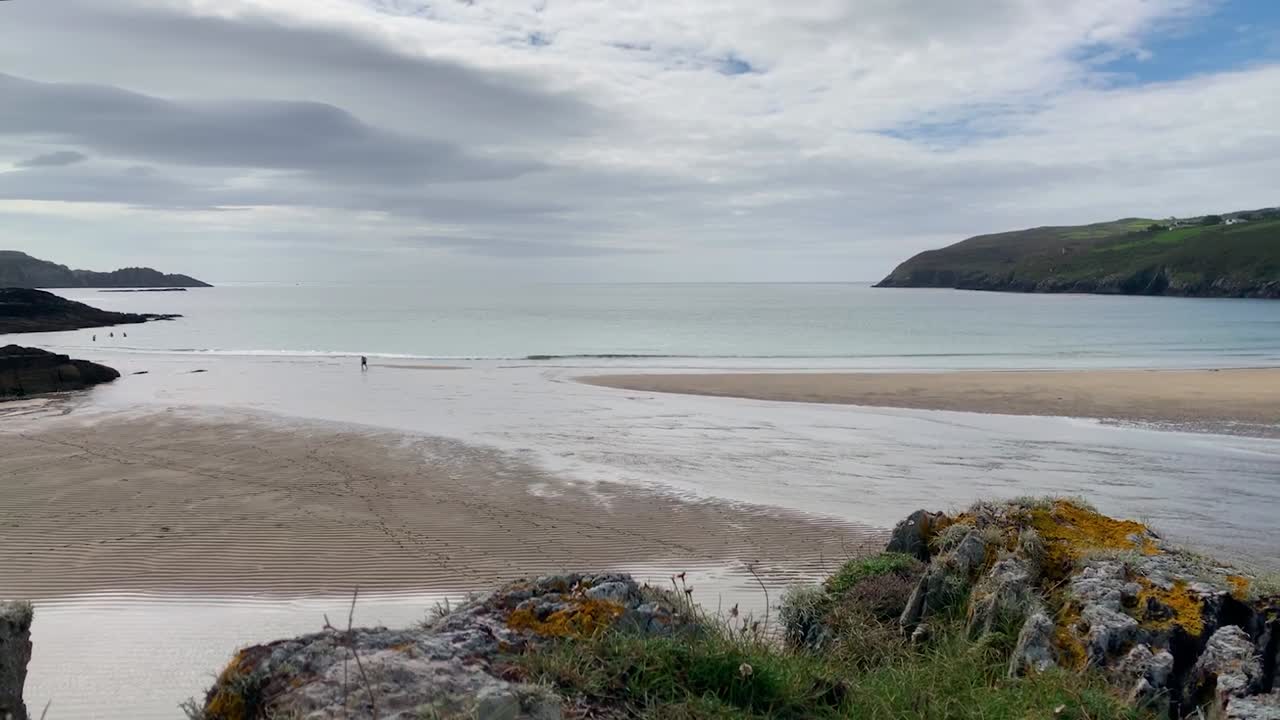 lapso de tiempo de las personas en una playa durante el reflujo con nubes en movimiento