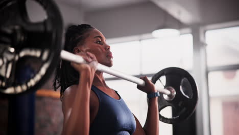 mujer levantando pesas en el gimnasio