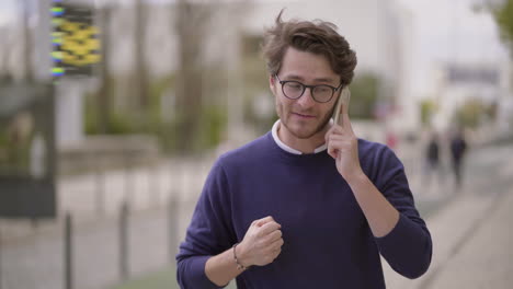 excited man talking by smartphone outdoor