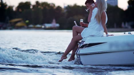 beautiful young couple drinking champagne on floating boat