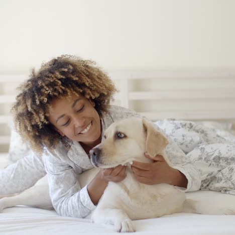 woman is holding a dog on a bed