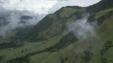 volando sobre el valle de cocora montañas andinas de color verde oscuro en salento colombia nube que atraviesa, parque nacional los nevados