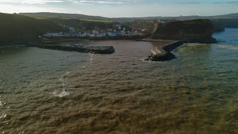 descending establishing drone shot of staithes coastal village and harbour uk