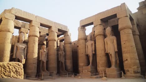 grands piliers et pylônes avec des statues de roche dans le temple de karnak, louxor, egypte