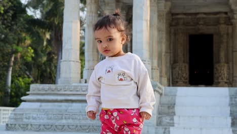 cute-toddler-innocent-expression-at-temple-courtyard-at-day-from-unique-perspective