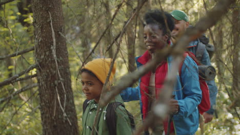 familia multiétnica caminando juntos en el bosque