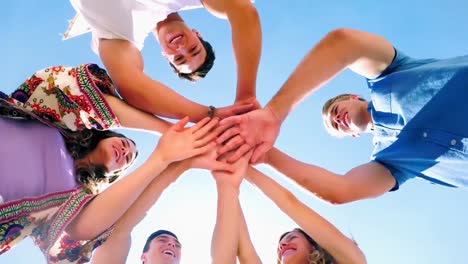 group of friends forming handstack at beach