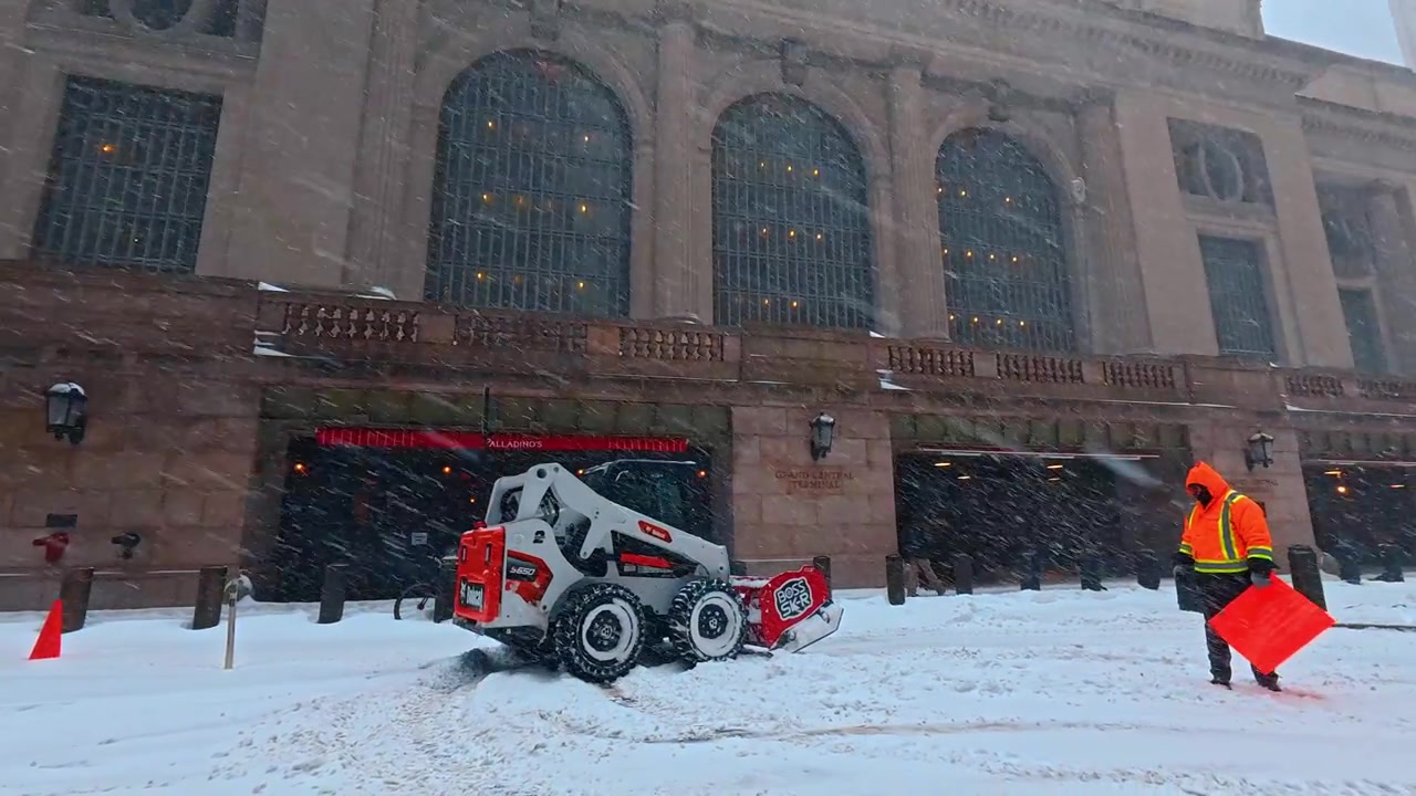 New York, USA, 25. december 2025: Parkerede biler ved Grand Central Terminal, Manhattan. Sne dækker køretøjer langs en smal gade ved siden af kontorbygninger.