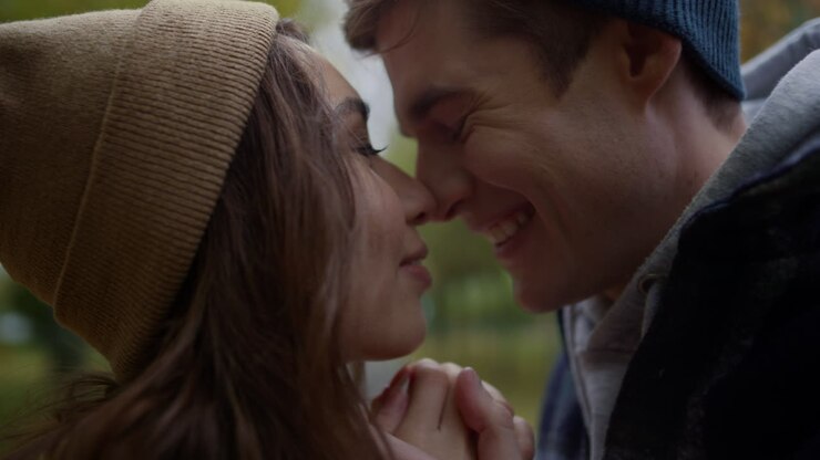 Jeunes amoureux joyeux se touchant le nez avec tendresse en extérieur
