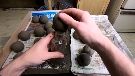 making a sphere out of clay using a glass jar