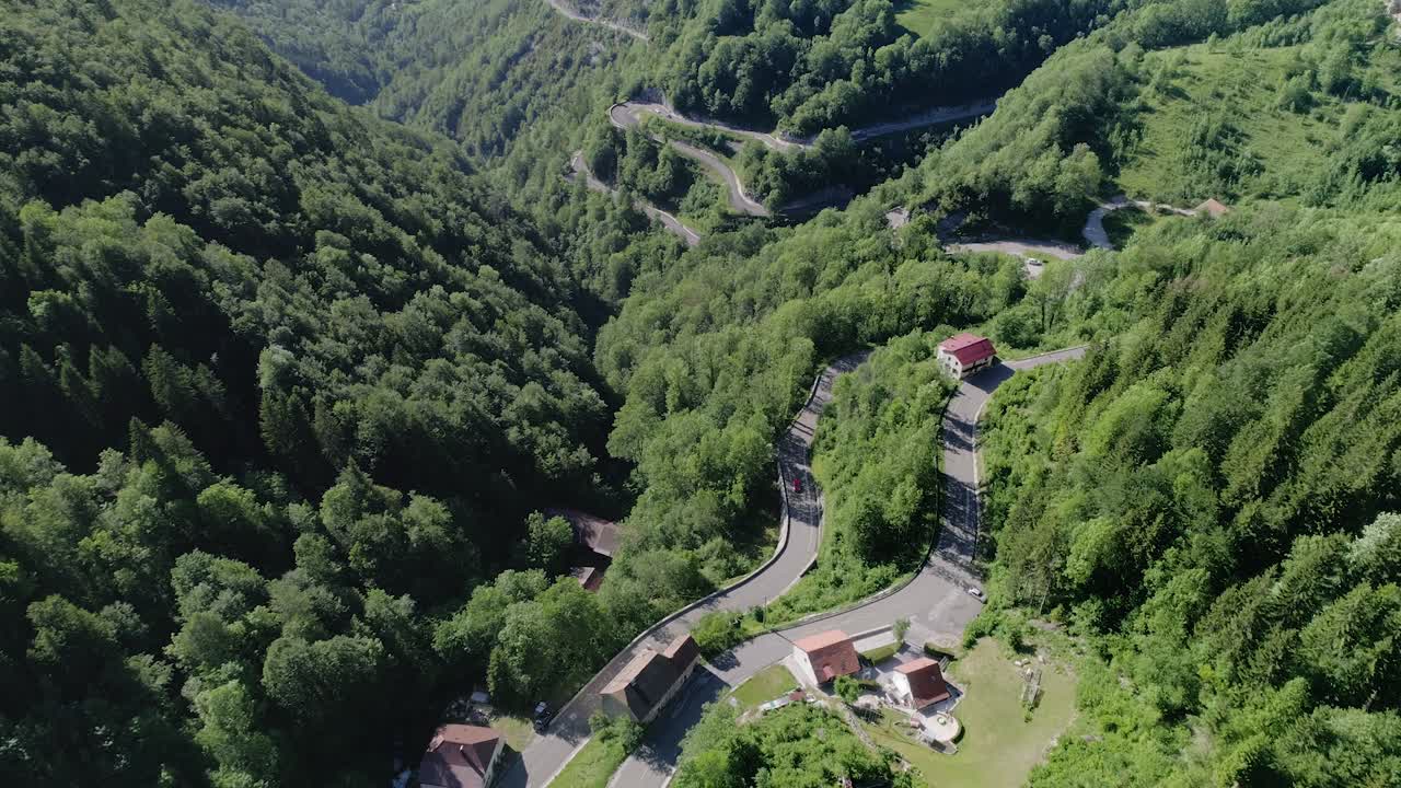 zoom de drones en la toma de una carretera de montaña con curvas en francia en un día soleado