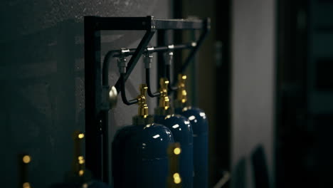 gas cylinders arranged neatly on a metal rack in a shadowy workshop