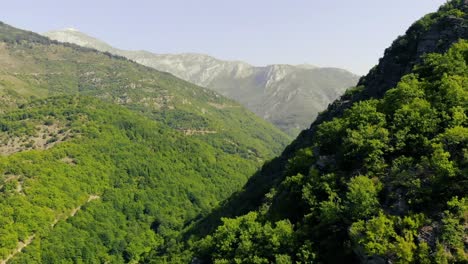 Tiro-Largo-Volando-Sobre-La-Montaña-Rocosa-Con-Una-Buena-Vista-A-Distancia-De-La-Vieja-Montaña-Verde