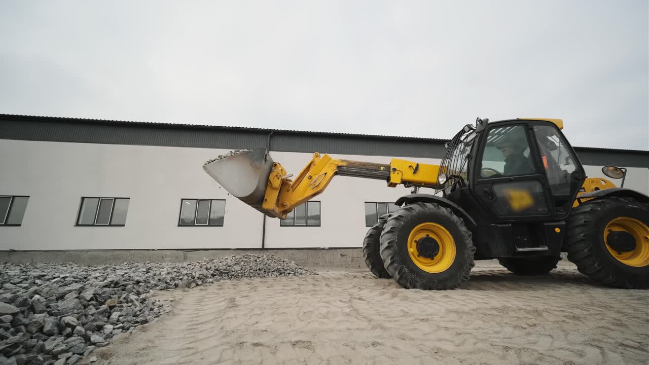 tractor mueve escombros al camión. excavadora-cargador rastrilla escombros de la pila en el sitio de construcción y carga el camión de descarga. sitio de limpieza