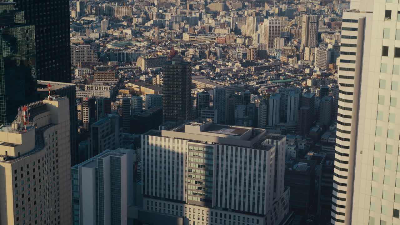 澄み切った昼光に照らされた東京新宿地区の空撮都市景観。