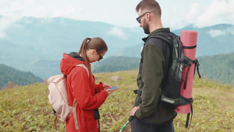 excursionistas en la cima de la montaña usando teléfonos inteligentes