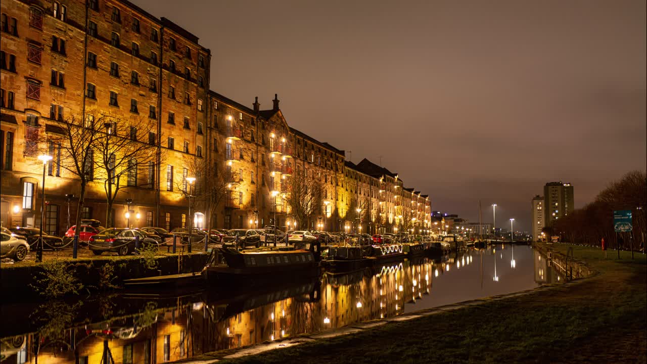 조명이 켜진 사암 건물이 있는 글래스고 중심에 있는 운하와 보트 하우스의 정적 샷