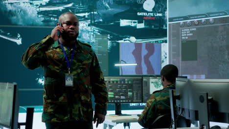 military specialist handles national operations with his crew in control center