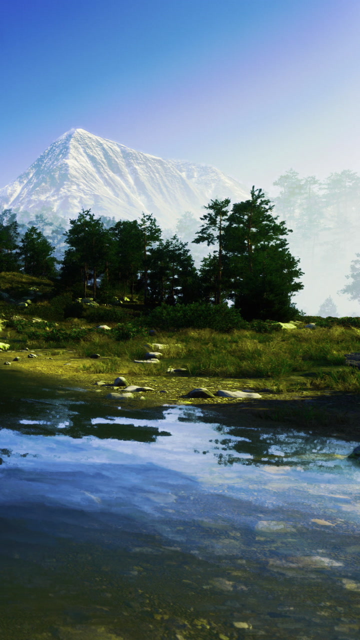 Mountains reflect in clear water with trees along the shore at sunset