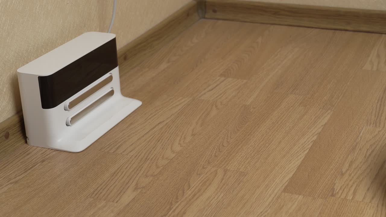 White Robotic Vacuum Cleaner Starts Cleaning From Its Charging Station