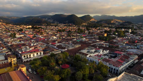 sunset casts a golden spell as we soar above san cristobal's lively townsquare—a vibrant tapestry of culture
