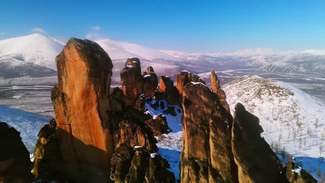 Rocky-mountains-in-winter-against-a-background-of-blue-sky-in-sunny-weather-from-a-drone