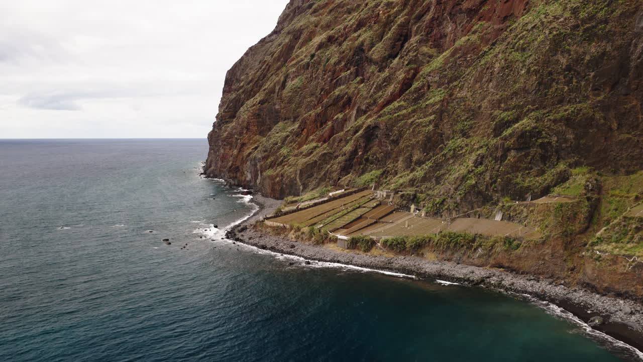 Vista Aérea de Falésias Costeiras Acidentadas com Campos em Socalcos e Praia de Seixos