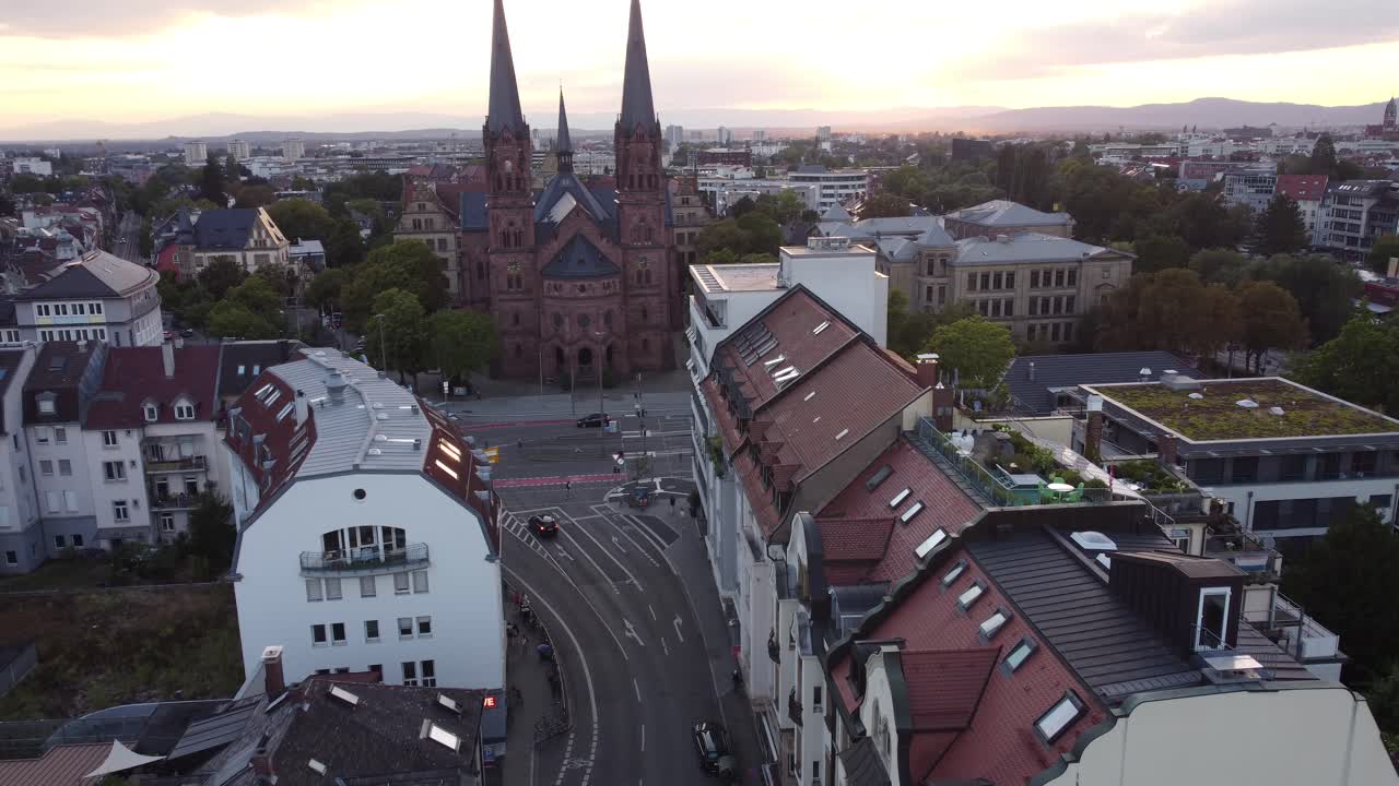 Aerial view of catholic church Johanneskirche in gothic old town of Freiburg im Breisgau during sunset, Germany