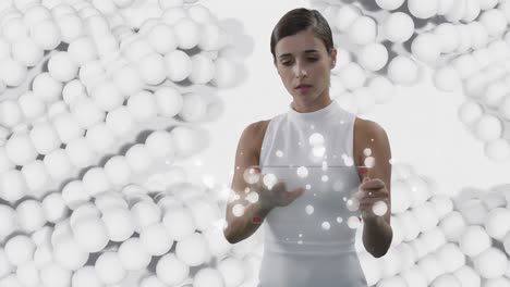mujer usando una pantalla interactiva transparente sobre bolas blancas pulsantes