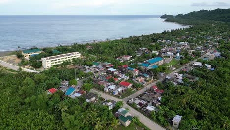 aerial overhead drone shot of coastal barangay with calm sea in background in catanduanes, philippines