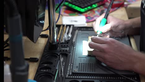 hombre reparando un taller de reparación de teléfonos con placa de microchip