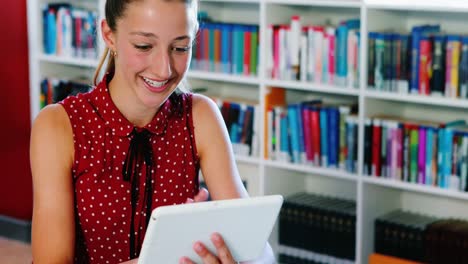 niña de escuela usando una tableta digital en la biblioteca