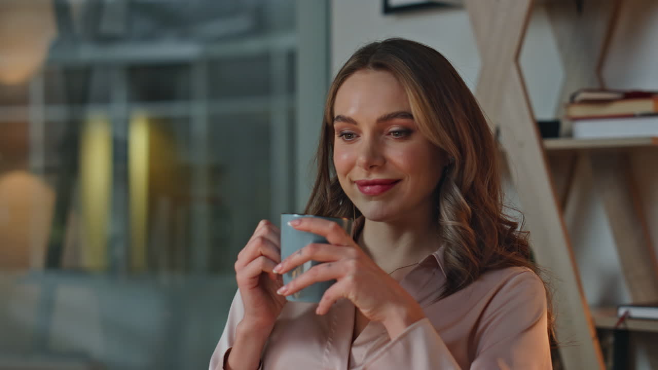 Woman enjoying warm drink in evening office. Closeup manager resting in chair