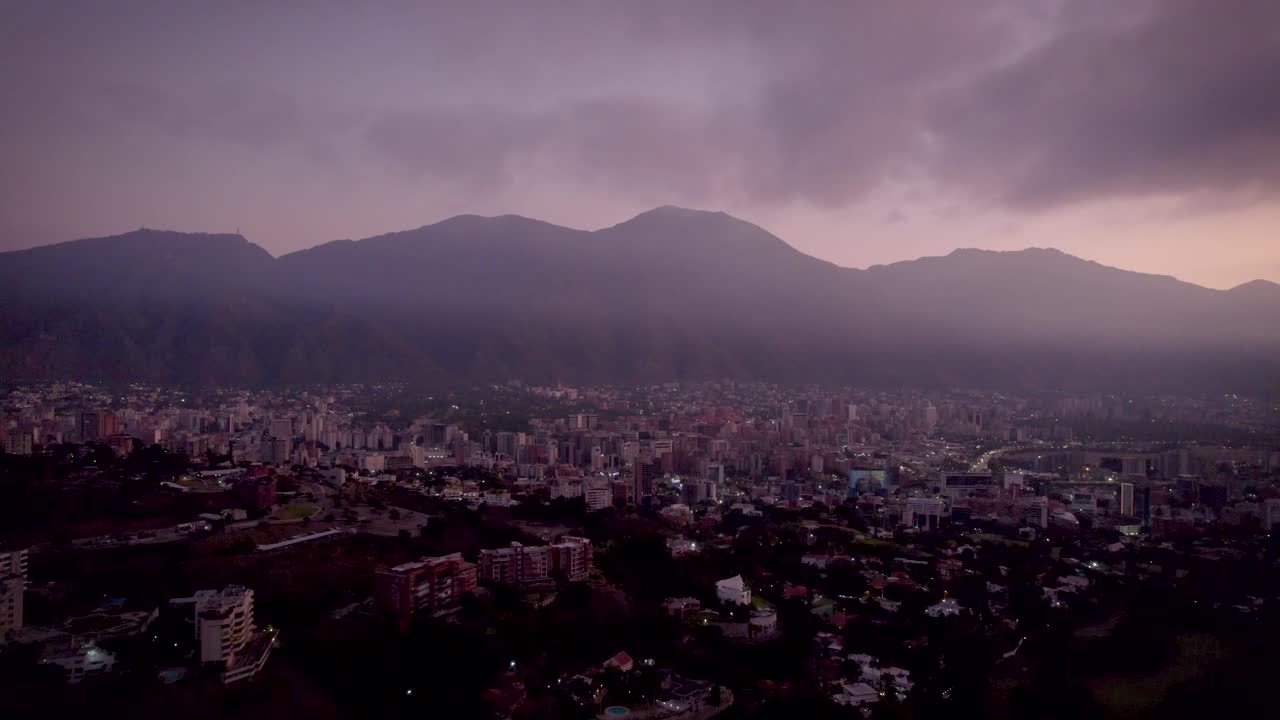 Drone view of a sunrise over Caracas City, Venezuela, with the Avila Mountain in the background.
