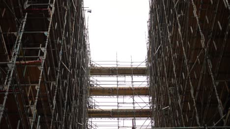 Mirando-Hacia-Los-Altos-Andamios-En-Un-Edificio-Rascacielos-En-Construcción-O-Renovación,-En-Un-Día-Nublado-En-Londres