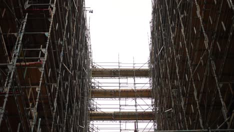 mirando hacia los altos andamios en un edificio rascacielos en construcción o renovación, en un día nublado en londres
