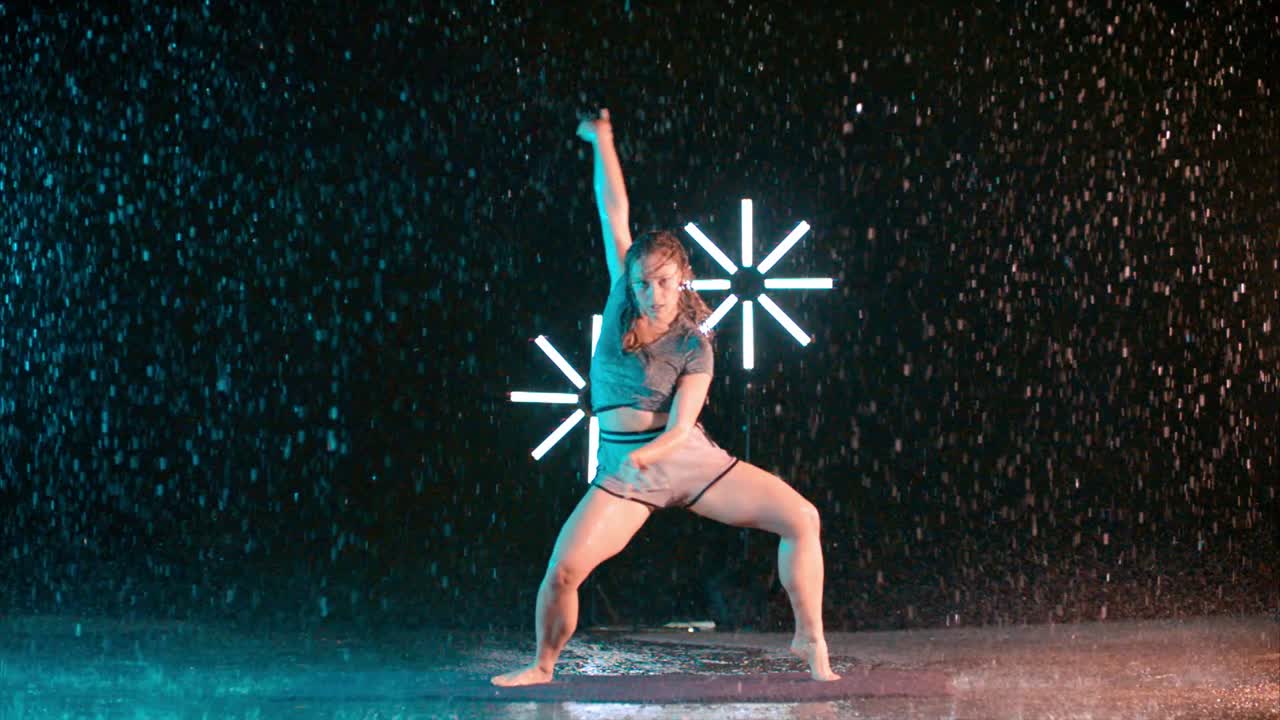Female dancer slow modern movement dancing in the rain, slow motion effect