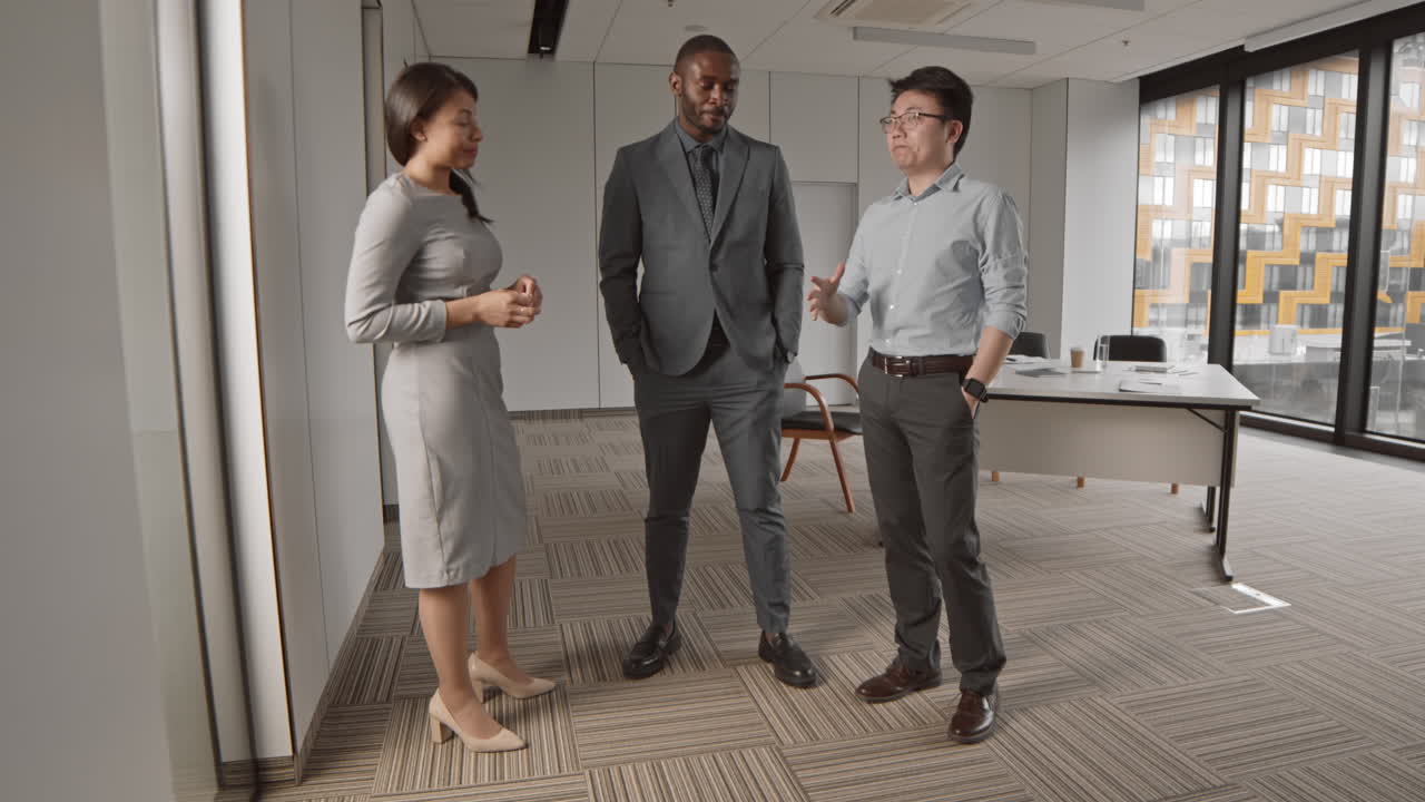 Three Multiethnic Businesspeople Having Talk in Office