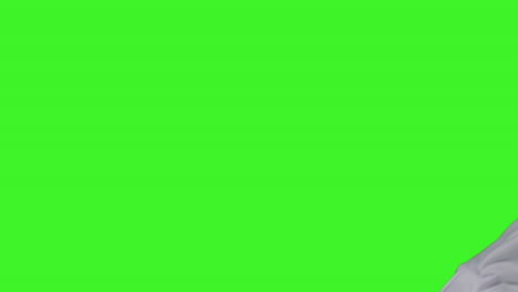 niño vestido con disfraces de fantasma truco o trato en halloween moviéndose a través del cuadro contra la pantalla verde del estudio
